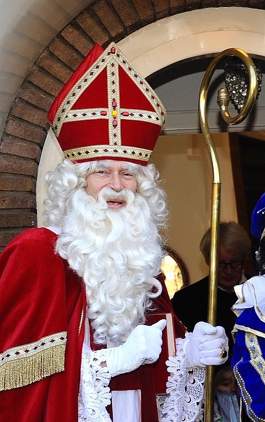 Sinterklaas gaat een woning binnen.